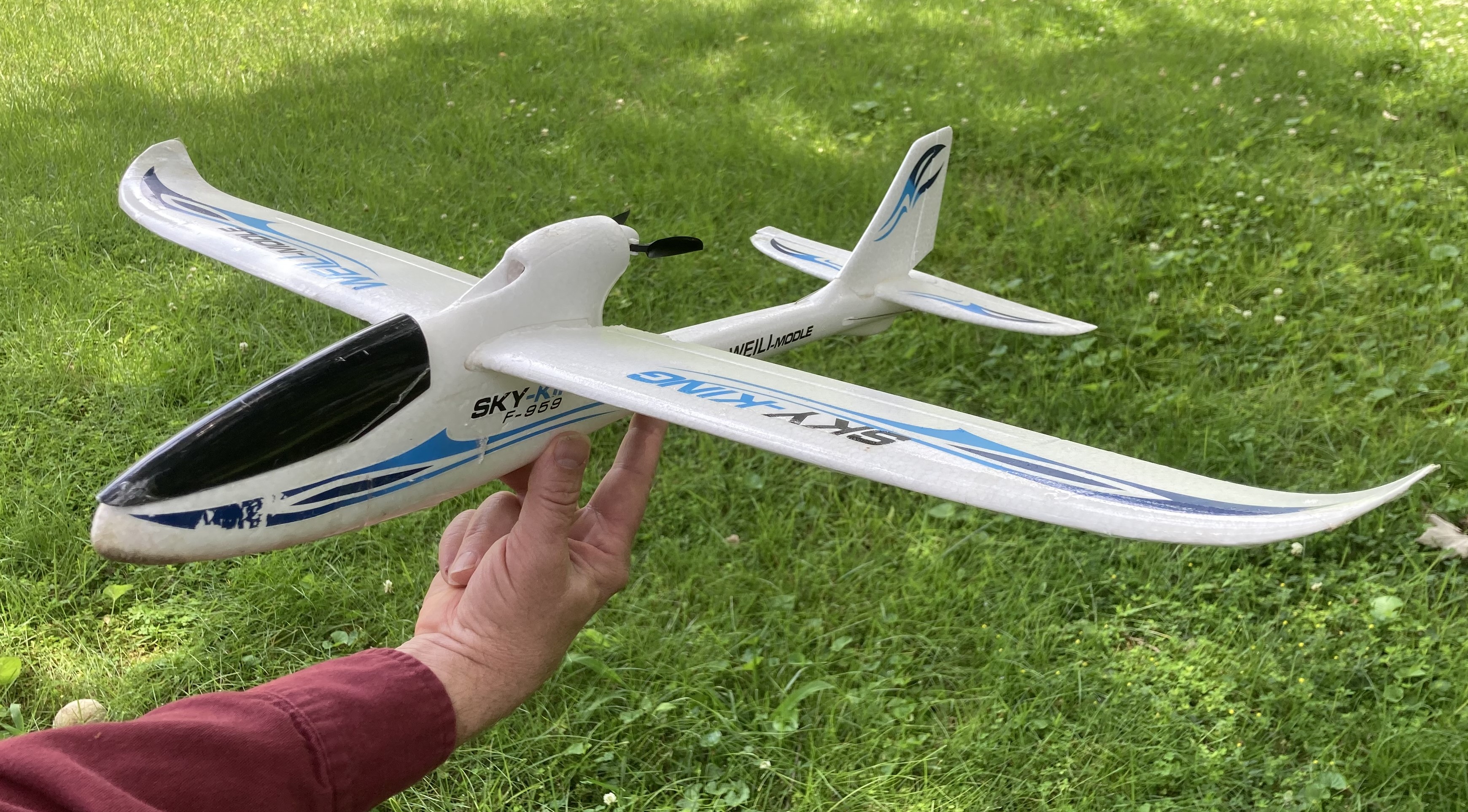 RC airplane being supported with three fingers